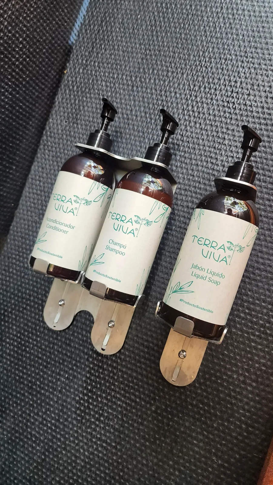 Tres dispensadores de productos de baño instalados en la ducha.
