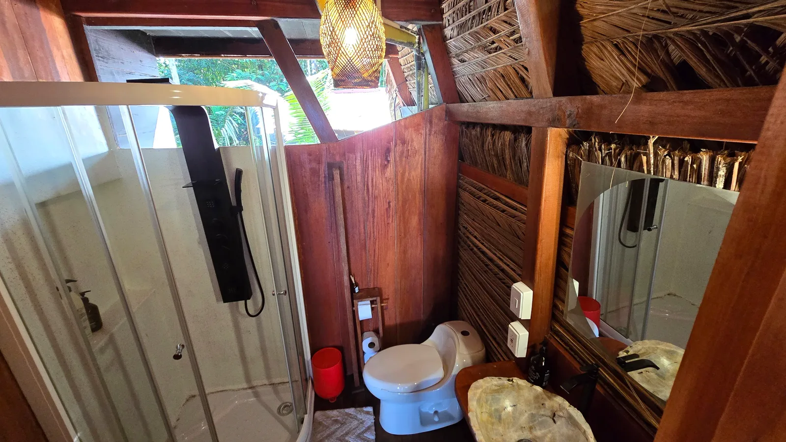 Baño de la cabaña VIP con ducha, inodoro y lavamanos de piedra.