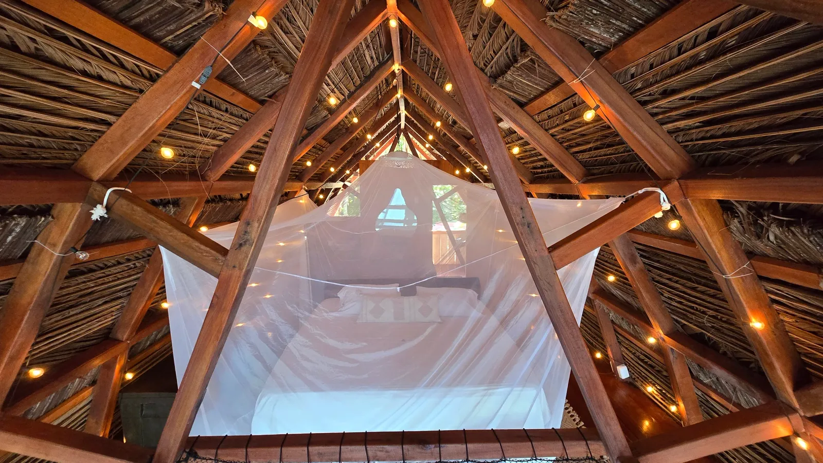 Vista frontal de la cama suspendida dentro de la estructura de madera.