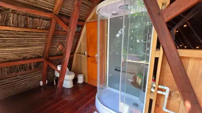 Ducha curva cerrada dentro de un baño amplio de madera.