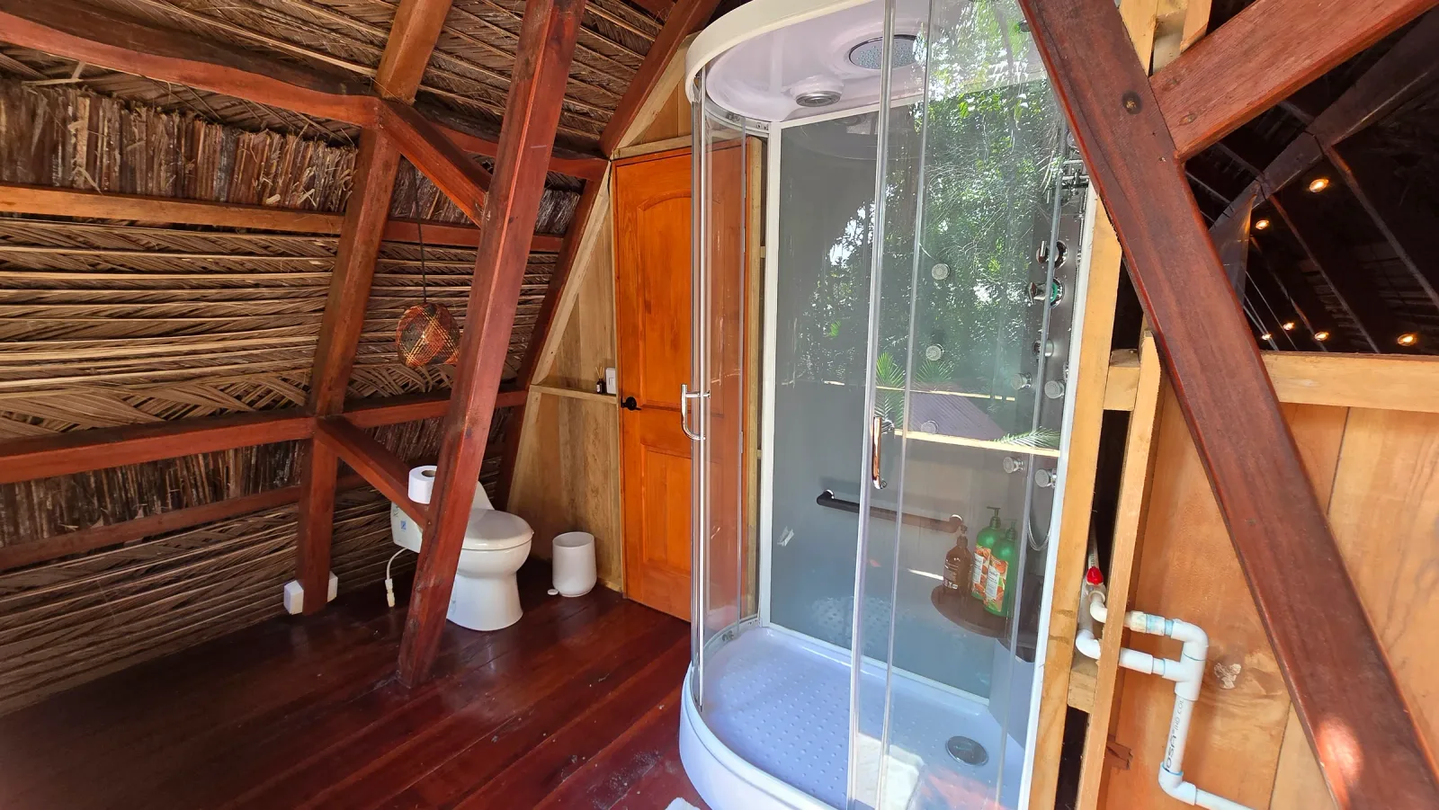 Ducha curva cerrada dentro de un baño amplio de madera.