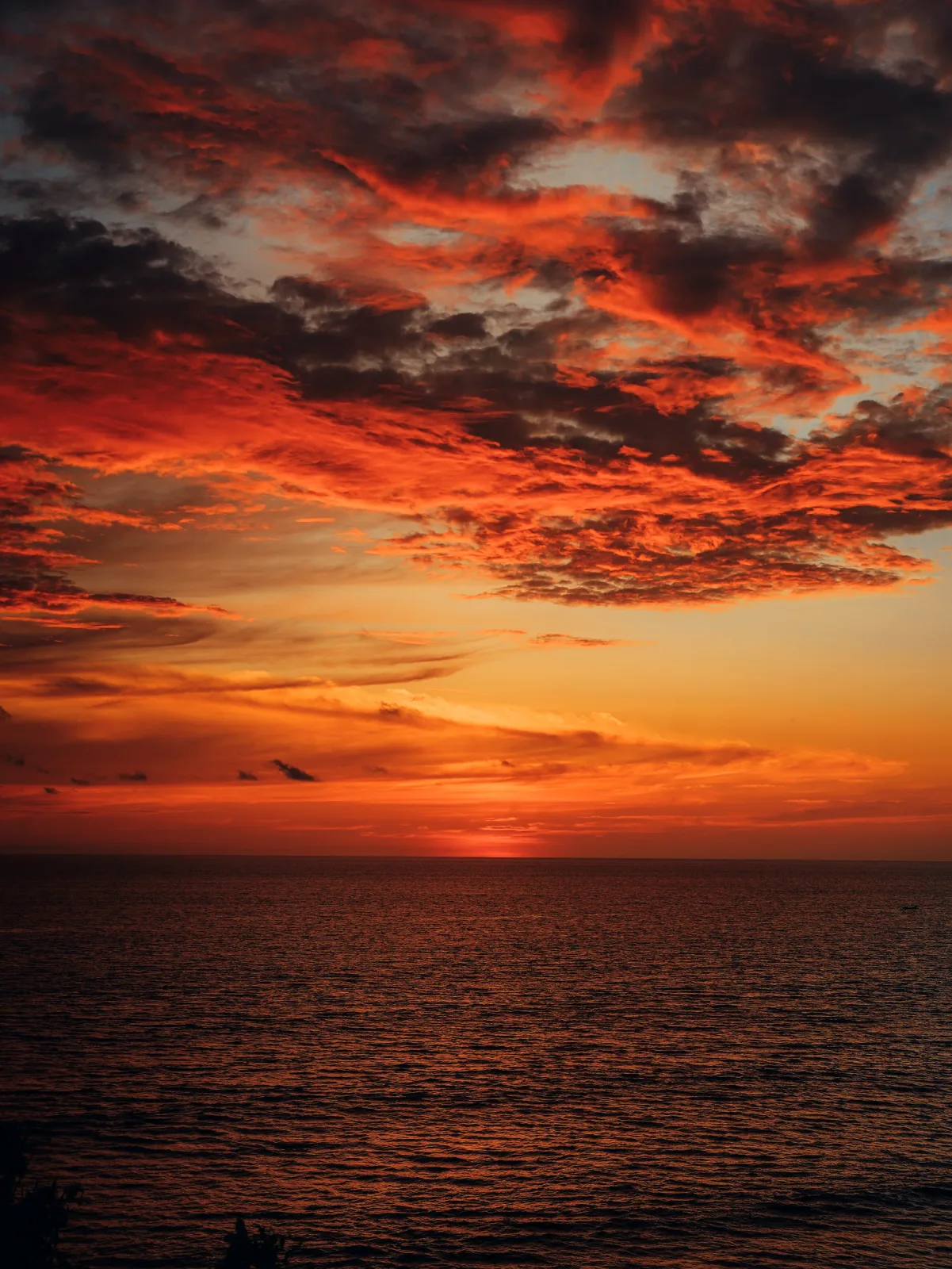 Atardecer de tonos rojos intensos sobre el mar.