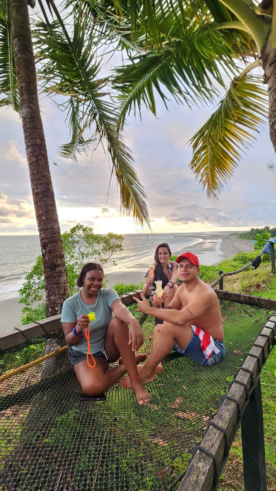 Grupo de amigos descansando sobre una red mirador con vista al mar.