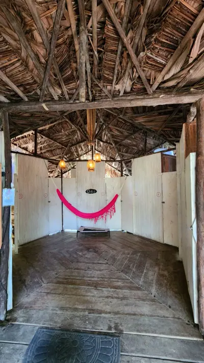 Pasillo rústico de acceso a los dormitorios cápsula bajo techo de palma.