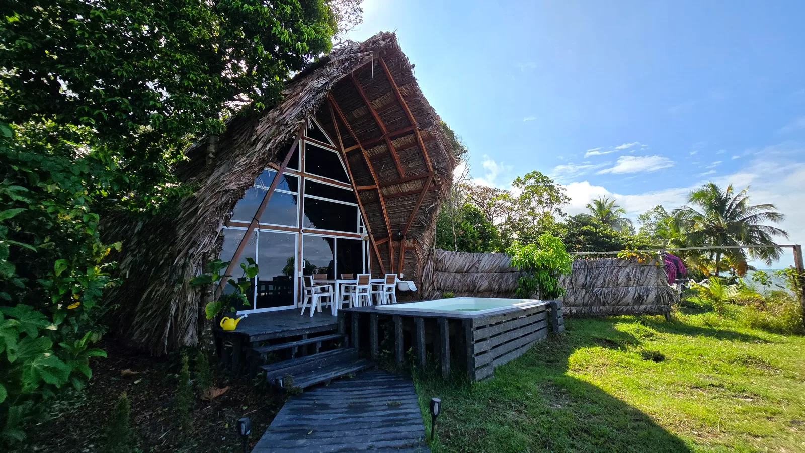 Fachada triangular de la cabaña VIP con gran ventanal y terraza.