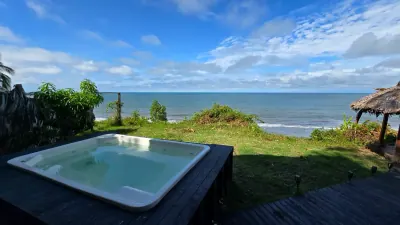 Piscina privada de la cabaña VIP con jardín y océano al fondo.