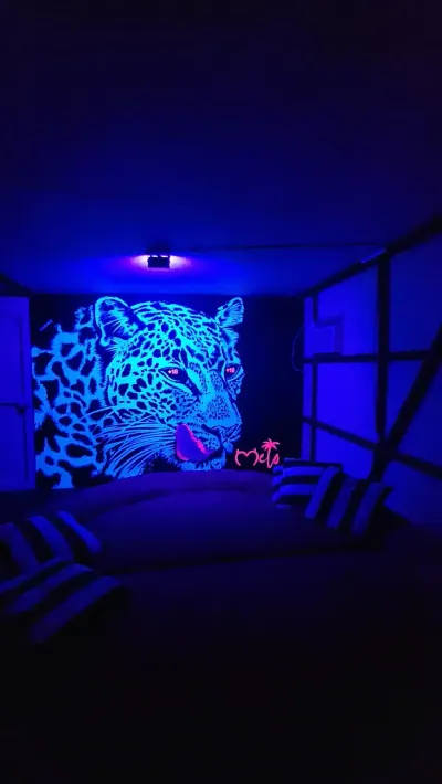 Mural de un felino iluminado con luz ultravioleta azul.