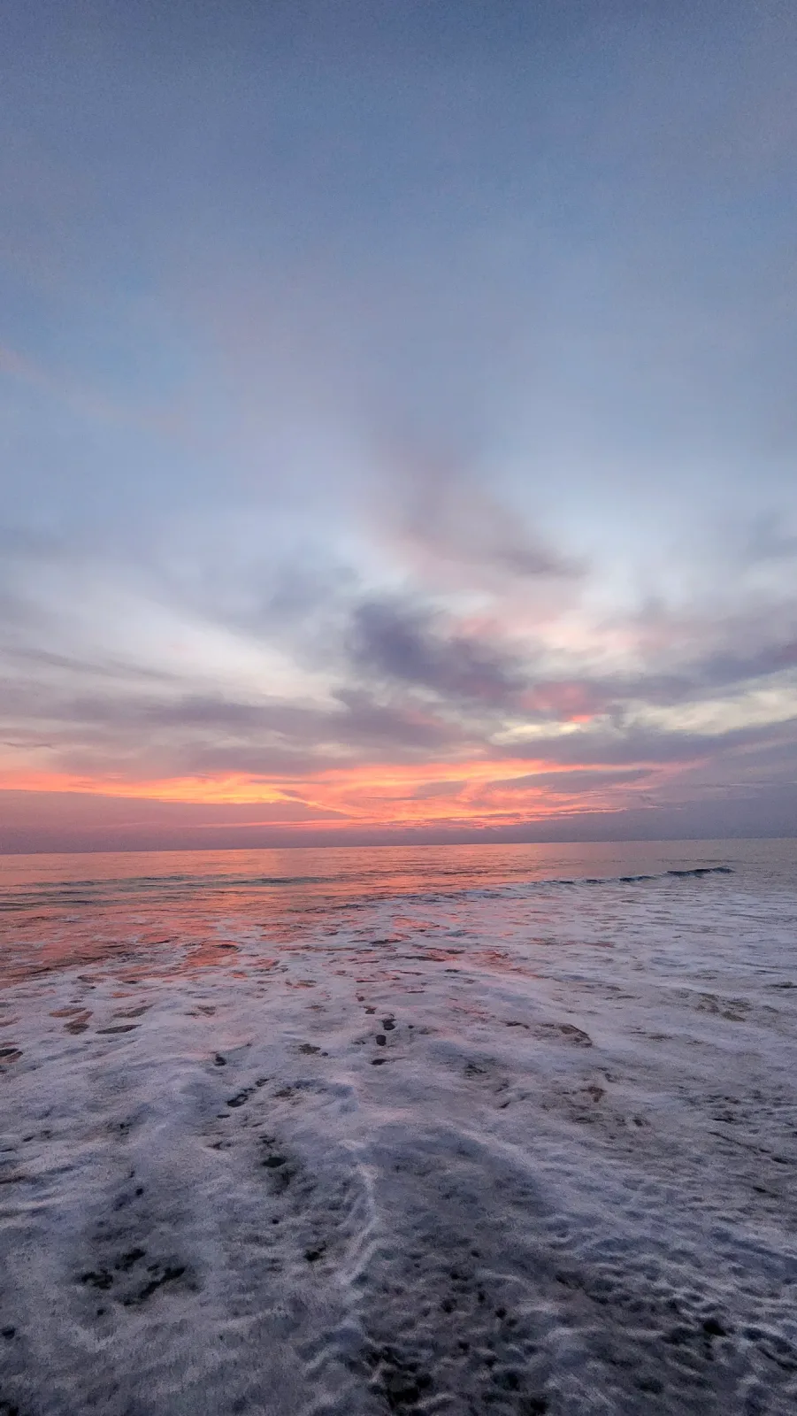 Oleaje del Pacífico bajo un cielo rosado y azul al atardecer.
