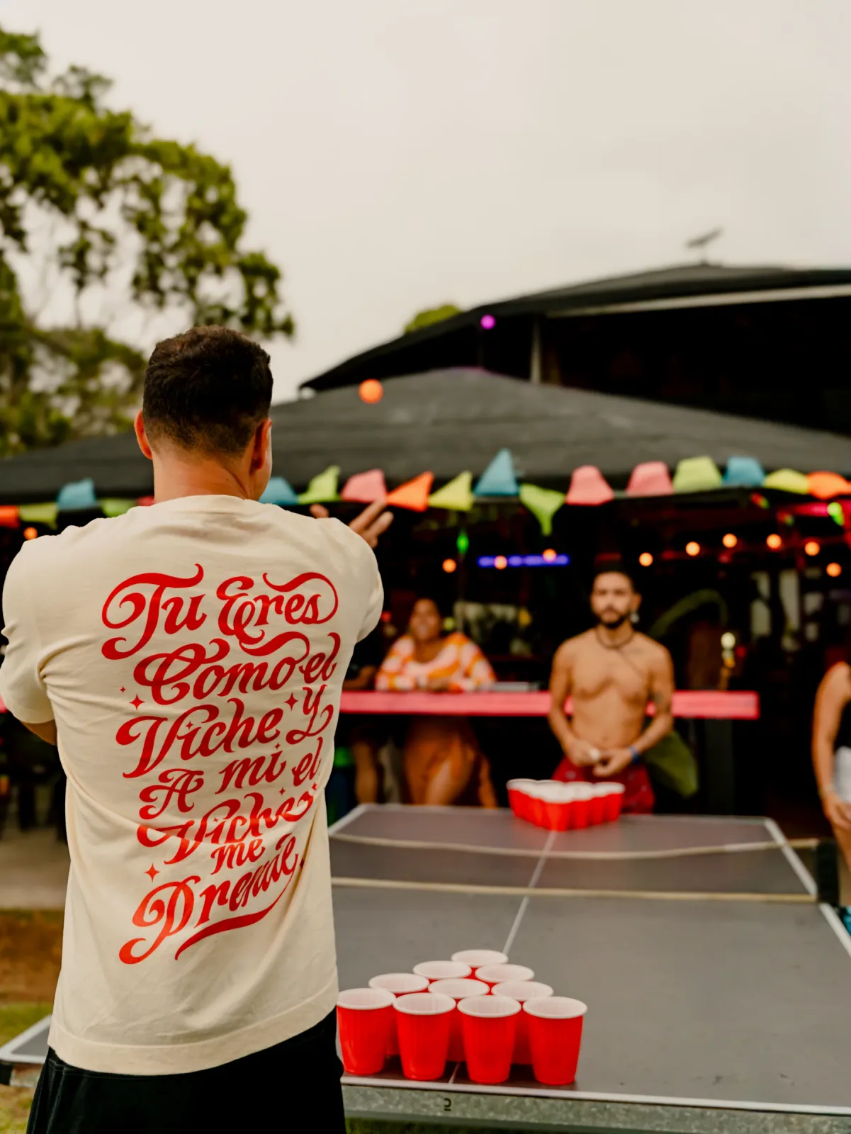 Visitante participando en una partida de beer pong durante un evento.