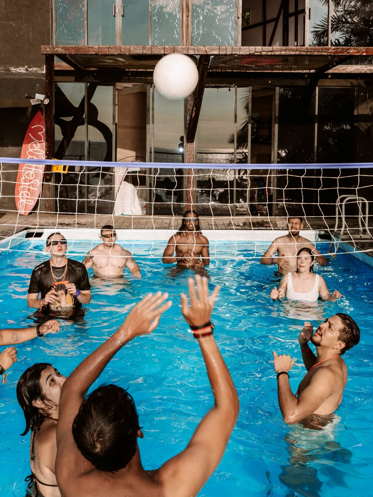 Grupo jugando voleibol dentro de la piscina.