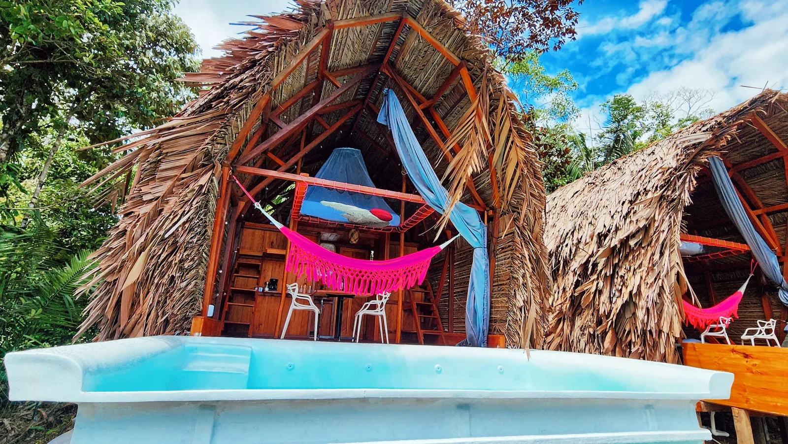 Fachada triangular de la cabaña Mamámelo con piscina privada en primer plano.
