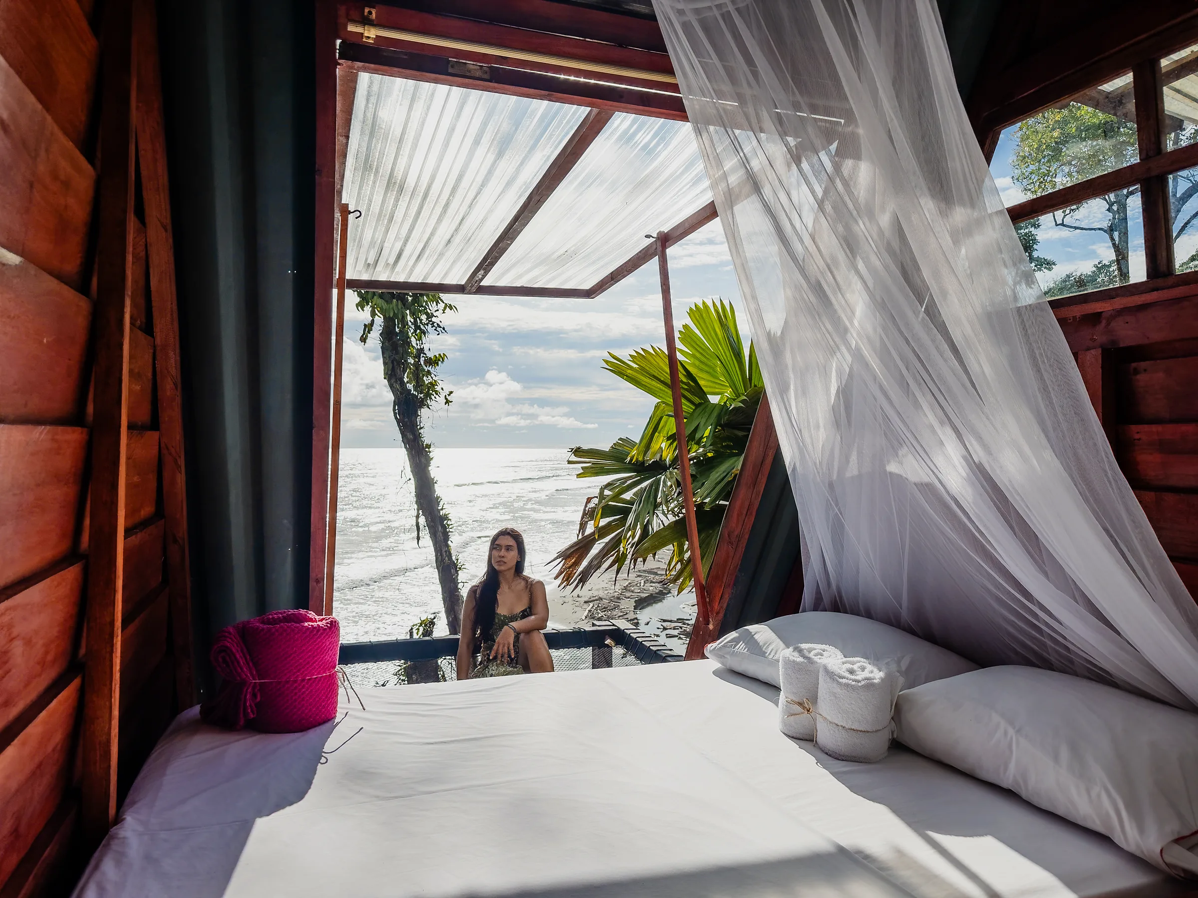 Cama con mosquitero y vista al mar desde la Alpina Deluxe.