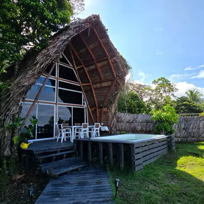 Cabaña de madera con terraza entre la selva.