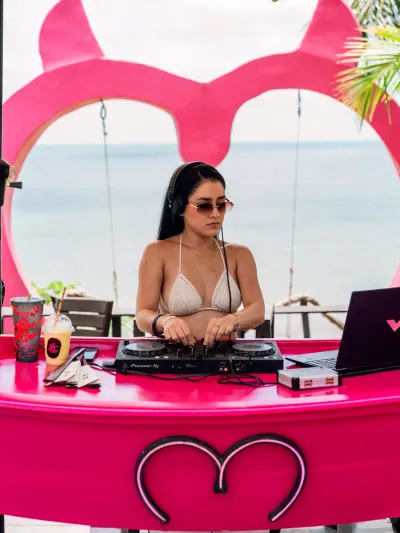 DJ en la cabina rosa frente al mar